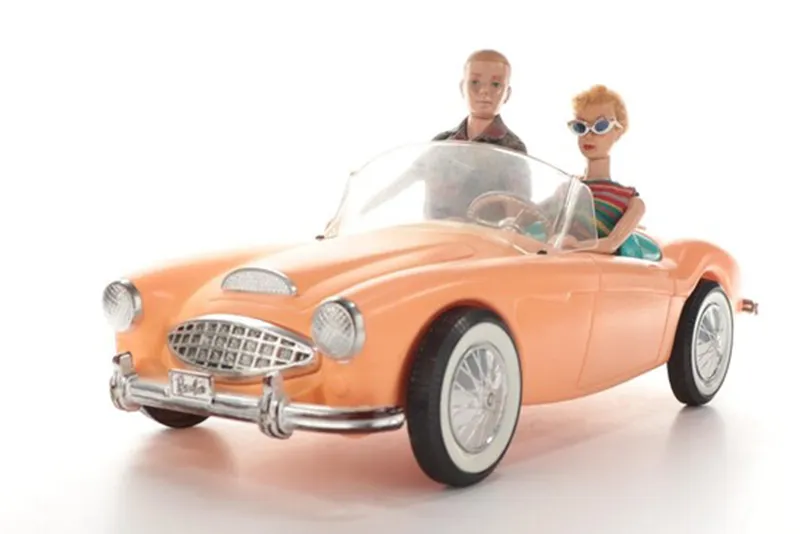 Dolls Barbie and Ken stylishly ride a peach convertible